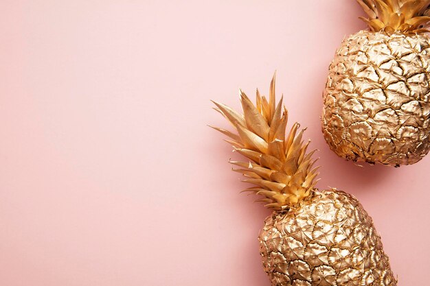 Gold tropische Ananas auf einem pastellrosa Hintergrund flach lag Sommer Hintergrund