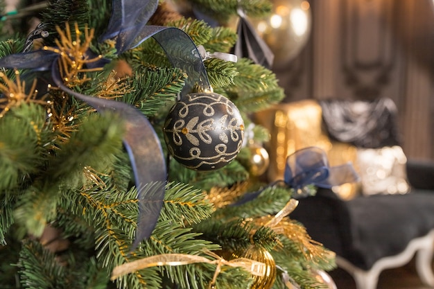 Gold und schwarze stilvolle Verzierungen auf Weihnachtsbaum