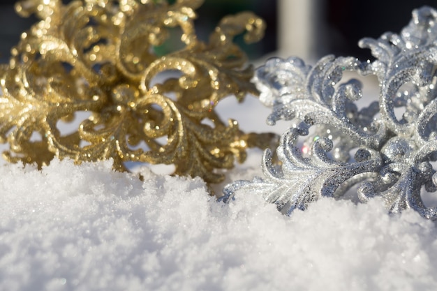 Gold und Silber Schneeflocke auf Schnee