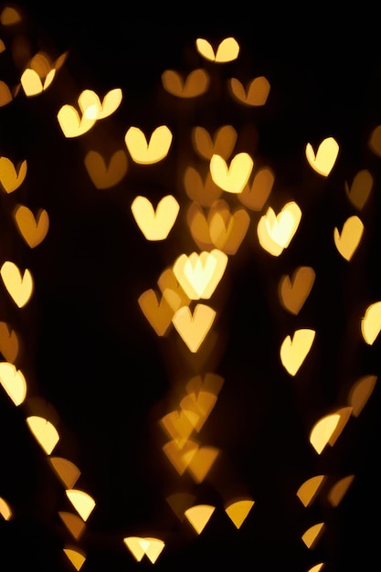 Goldbokeh in Form eines Herzens Festlicher Hintergrund