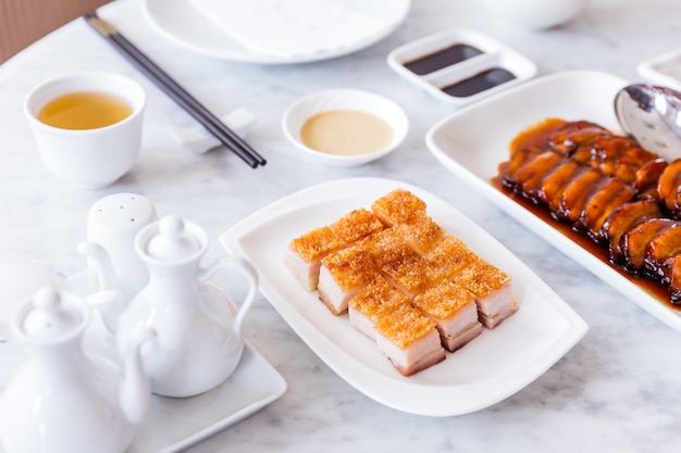 Golden Crispy Pork Belly cut in cubed servido con salsa de mostaza.