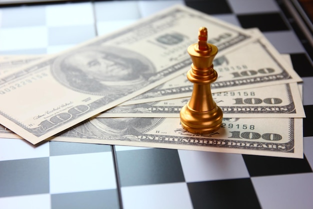 Golden King Chess auf US-Dollar-Banknote auf Schachbrettspiel, Geschäftskonzept