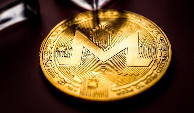 Golden Monero XRM em fundo rosa claro Closeup tiro macro Criptomoeda