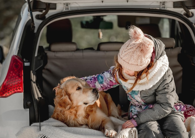 Golden Retriever-Hund mit Mädchen im Winter