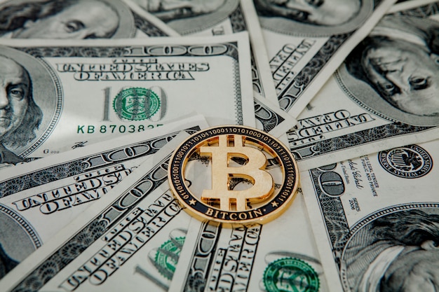 Goldene Bitcoin auf US-Dollar-Scheinen. Konzept des elektronischen Geldwechsels