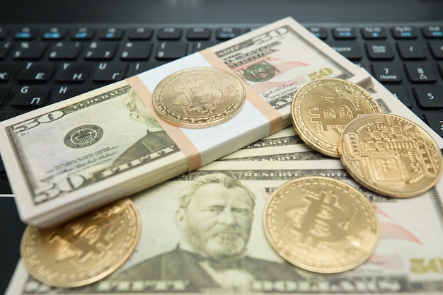 Goldene Bitcoin-Münze auf US-Dollar hautnah. Symbolisches Bild der virtuellen Währung.