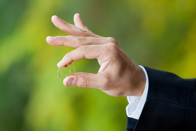 Goldene Eheringe an der Hand des Bräutigams