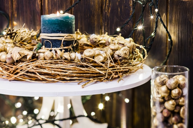 Goldene Eicheln und Tannenzapfen in Gläsern und Kranz, Kerzenlicht und Dekoration für Weihnachten