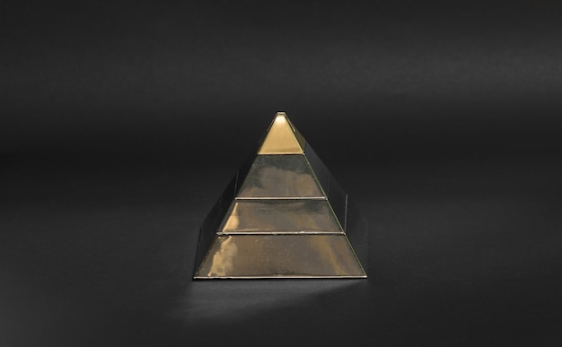 Foto goldene finanzpyramide auf schwarzem hintergrund