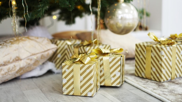 Goldene Geschenkkisten unter dem Weihnachtsbaum