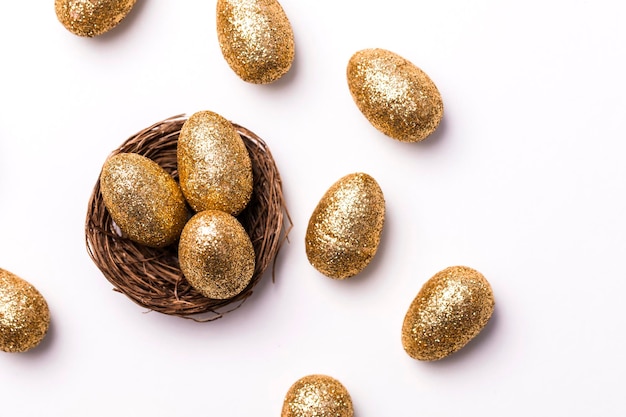 Goldene Glitzereier in einem Nest Ostern-Hintergrund Finanzkonzept