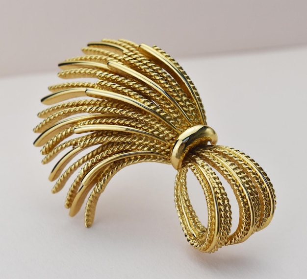 Goldene Haarschnalle auf weißem Hintergrund Nahaufnahme selektiver Fokussierung