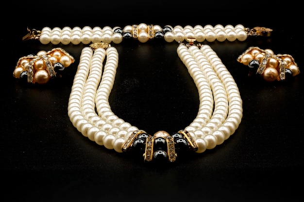 Goldene Halskette mit Anhängern auf schwarzem Hintergrund Jewel Design