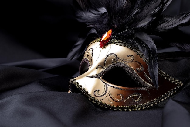 goldene Maske auf schwarzer Seide