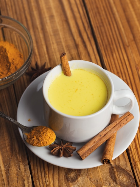 Foto goldene milch mit gelbwurz auf holztisch