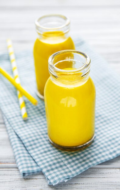 Goldene Milch mit Zimt, Kurkuma, Ingwer und Honig über weißer Holzoberfläche