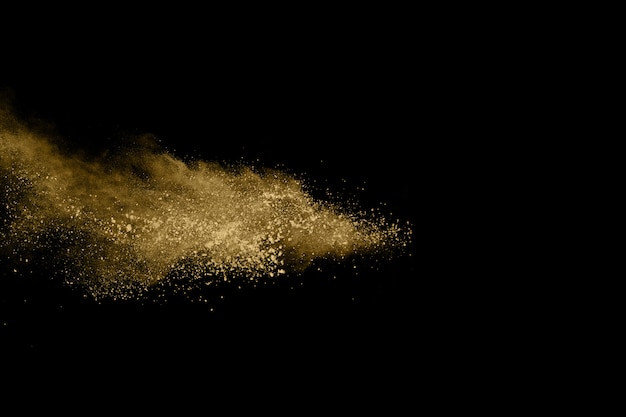 Goldene Pulverexplosion auf schwarzem Hintergrund.