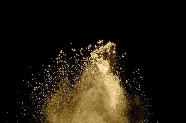 Goldene Pulverexplosion auf schwarzem Hintergrund