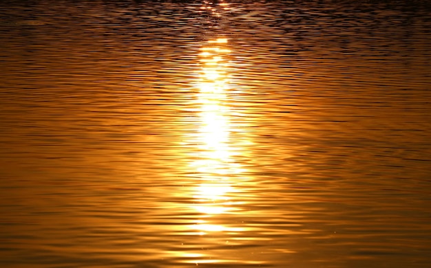 Goldene Reflexionen des Sonnenaufgangs auf der Wasseroberfläche