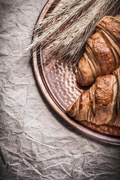 Goldene Roggenweizenohren frische Croissants Kupfertablett auf Geschenkpapier