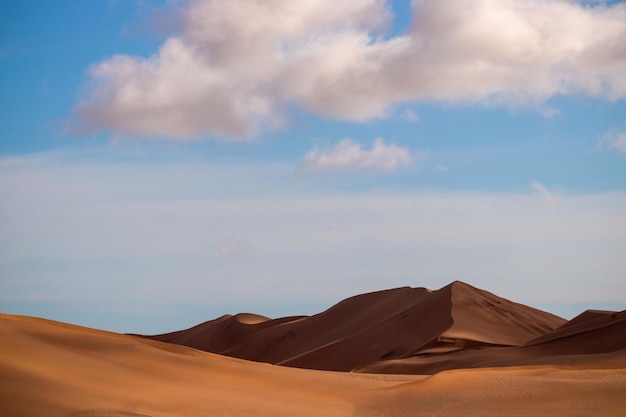 Goldene Sanddüne 7 und weiße Wolken an einem sonnigen Tag in der Namib-Wüste. Fantastischer Ort für Reisende und Fotografen