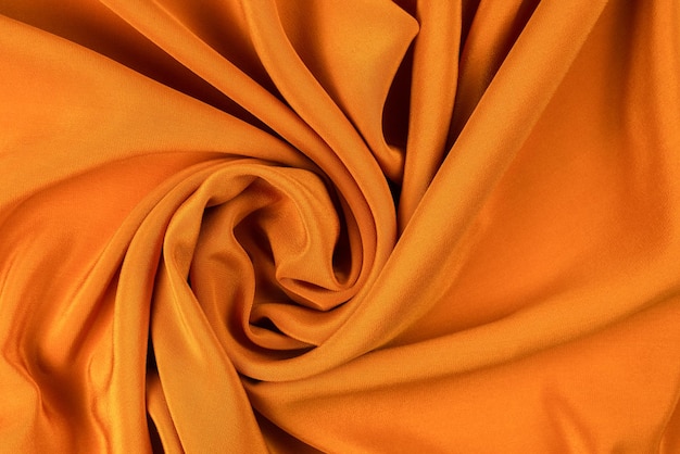 Goldene Seiden- oder Satin-Luxus-Textur kann als abstrakter Hintergrund verwendet werden. Ansicht von oben.