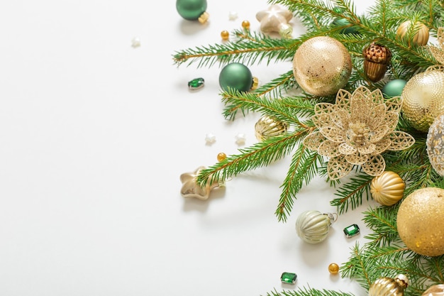 Goldene und grüne Weihnachtsdekorationen auf weißem Hintergrund