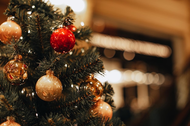 Goldene und rote Weihnachtskugeln hängen am Weihnachtsbaum Bokeh-Zaubereffekt Festlicher Winter