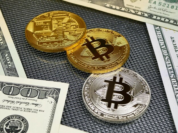 Goldene und silberne bitcoin Münzen und amerikanische Dollaranmerkungen über Auszug.