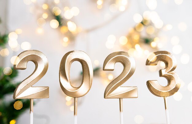 Goldene Zahlen 2023 der frohen Weihnachten und des guten Rutsch ins Neue Jahr auf festlichem Hintergrund mit Lichtern