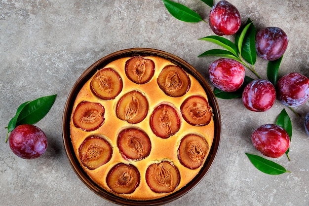 Goldener Biskuitkuchen mit roter Pflaume. Ansicht von oben.