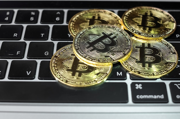 Goldener Bitcoin-Kryptowährungs-Münzstapel auf Laptoptastatur