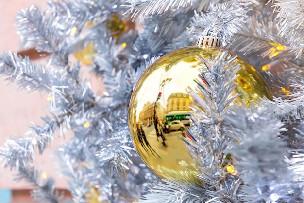 Goldener glänzender Ball auf weihnachtlich geschmückter Straße in Paris Frankreich