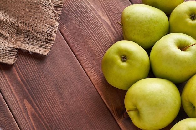 Goldener köstlicher Apfel auf braunem Hintergrund