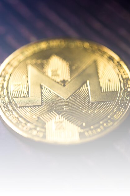 Goldener Monero XRM auf dunklem Holzhintergrund Nahaufnahme Makroaufnahme Neues virtuelles Geld