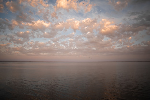 Goldener Sonnenuntergang mit buntem Himmel und buntem Wasser im See reflektiert am Abend