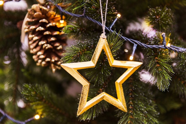 Goldener Stern mit Kegel auf Weihnachtsbaum. Dekorationen für das neue Jahr