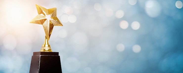 Goldener Trophäenpreis Bokeh weicher blauer Hintergrund, Gewinner oder 1. Platz Goldtrophäenpreiskonzept