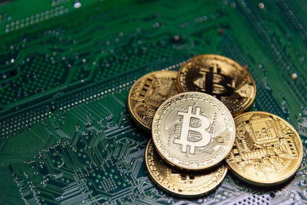 Goldenes bitcoin auf grünem Motherboard.