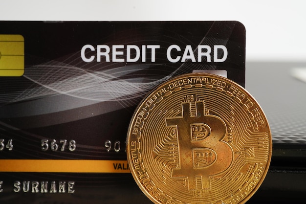 Goldenes Bitcoin mit Kreditkarte auf US-Dollar-Banknotengeld für Geschäfts- und kommerzielle Digital