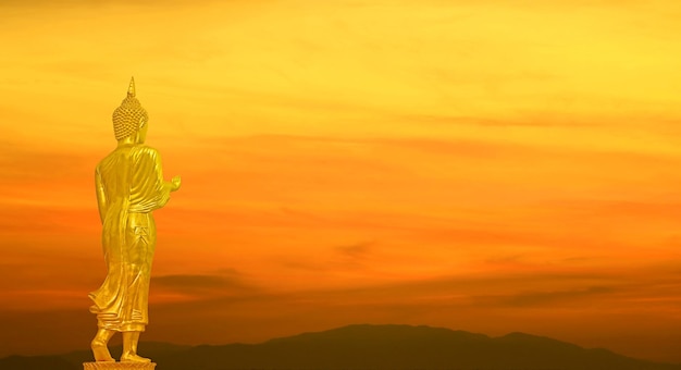 Goldenes Buddha-Bild auf orangefarbenem Farbverlauf Sonnenaufgangshimmel über den Bergen