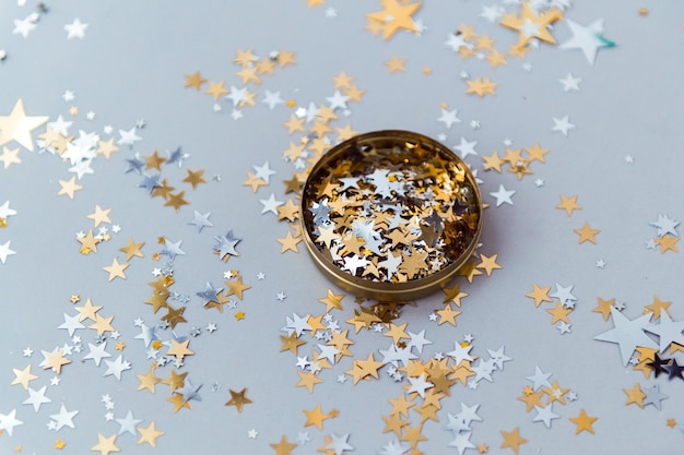 Goldenes Konfetti im Blechglas auf blauem Hintergrund