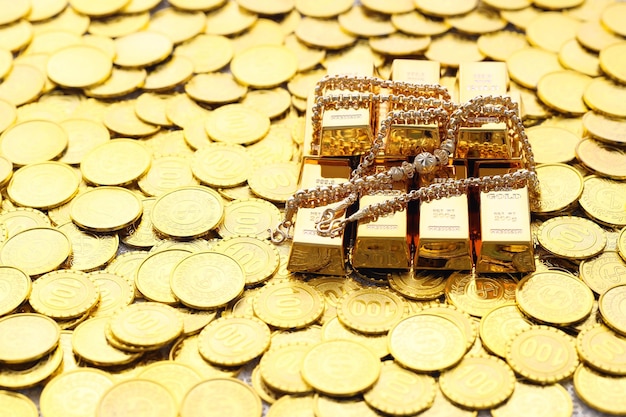 Goldhalsketten und Goldbarren mit Stapel Münzen Geld auf gelbem Hintergrund Unternehmensinvestitionen und Geld sparen für die Vorbereitung auf das zukünftige Konzept