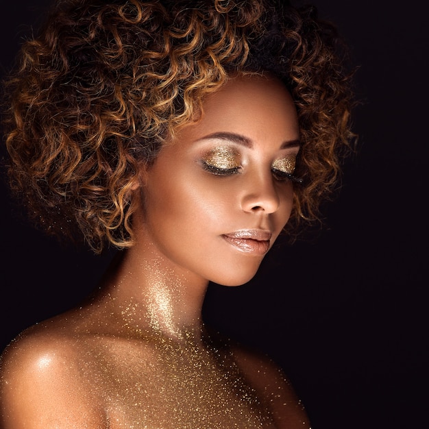 Goldhaut - Afroamerikanerfrau - schönes Make-up-Konzept der Schönheitsfrisur. Studioaufnahme.