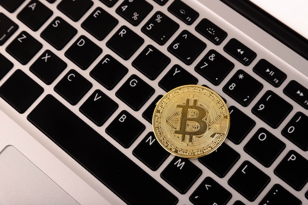 Goldmünze Bitcoin, liegt auf einem Laptop, Tastatur