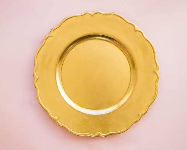 Foto goldplatte auf rosafarbener tabelle