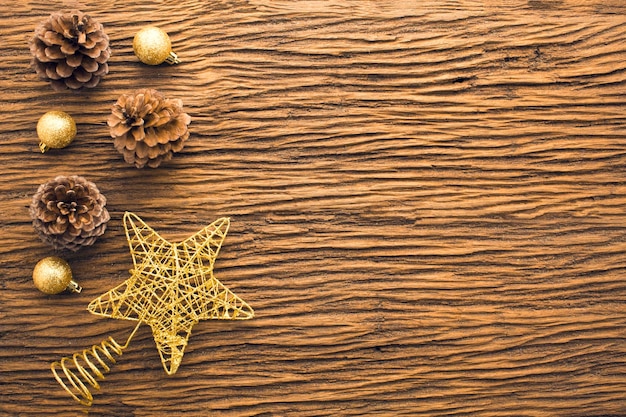 Goldsternglitterdekor mit Holzkiefernkegel im Weihnachtskonzept mit flacher Draufsicht