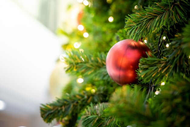 Goldweihnachtshintergrund von de-fokussierten Lichtern mit verziertem Baum