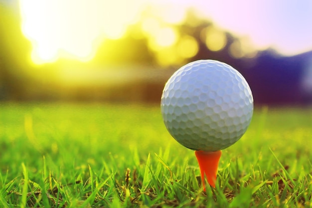 Golfball auf Abschlag in einem schönen Golfplatz mit Morgensonne