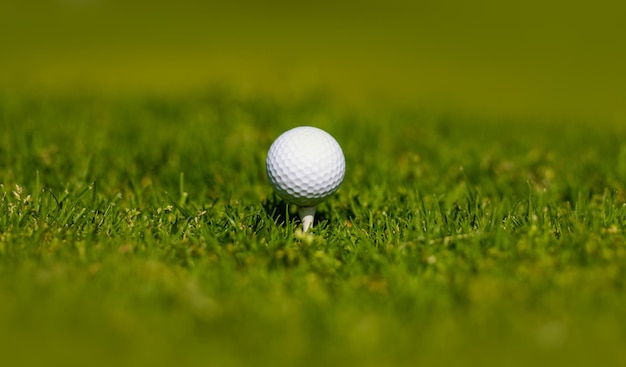 Golfball auf T-Stück, das bereit ist, erschossen zu werden Golfclubhintergrund